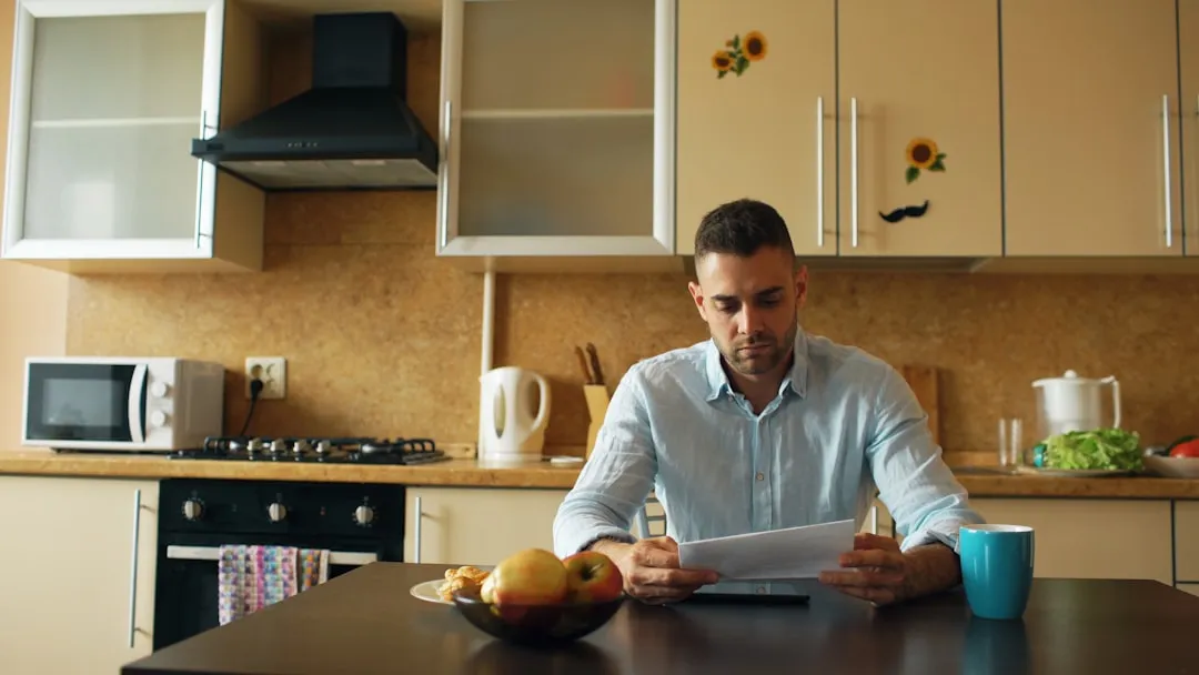 Man reviewing letter at kitchen table